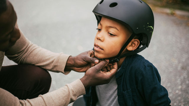 father-putting-helmet-on-his-kid-small